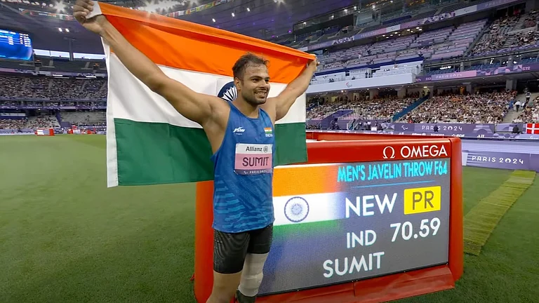 Sumit Antil poses with the Indian flag after winning gold in the Men's Javelin F64 category. - PCI